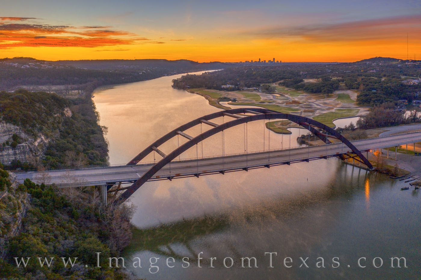 Taken with a drone, this December sunrise photograph looks over the 360 Bridge. In the distance is the downtown Austin skyline...