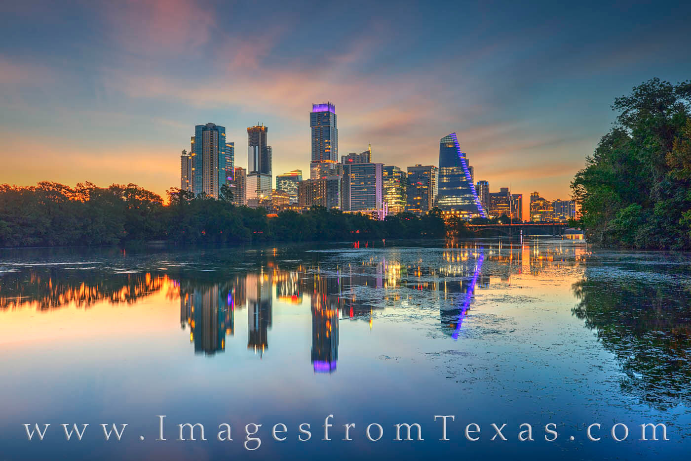 On a very calm and warm late August morning, the quiet Austin skyline shows its reflection in the still water of Lady Bird Lake...