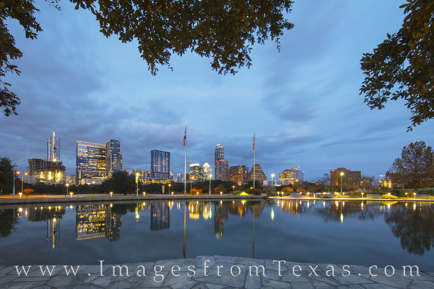 The Austin skyline rises into a cold December evening as reflections of the high rises shimmer in the still water near the Long...