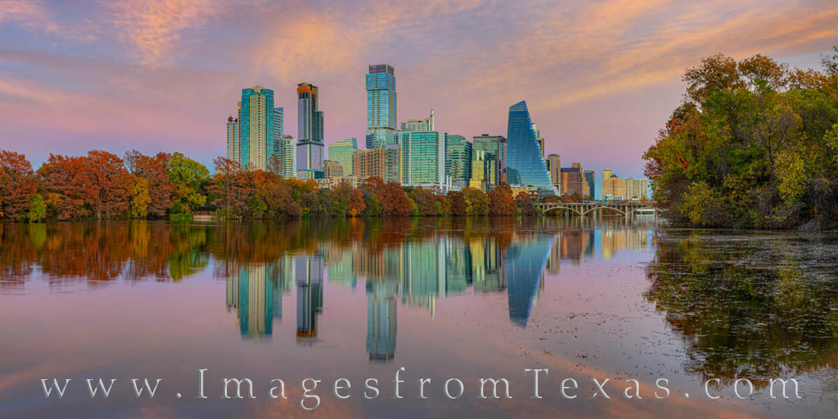 The trees along Lady Bird Lake in downtown Austin show off their fall colors on a calm, late November evening.