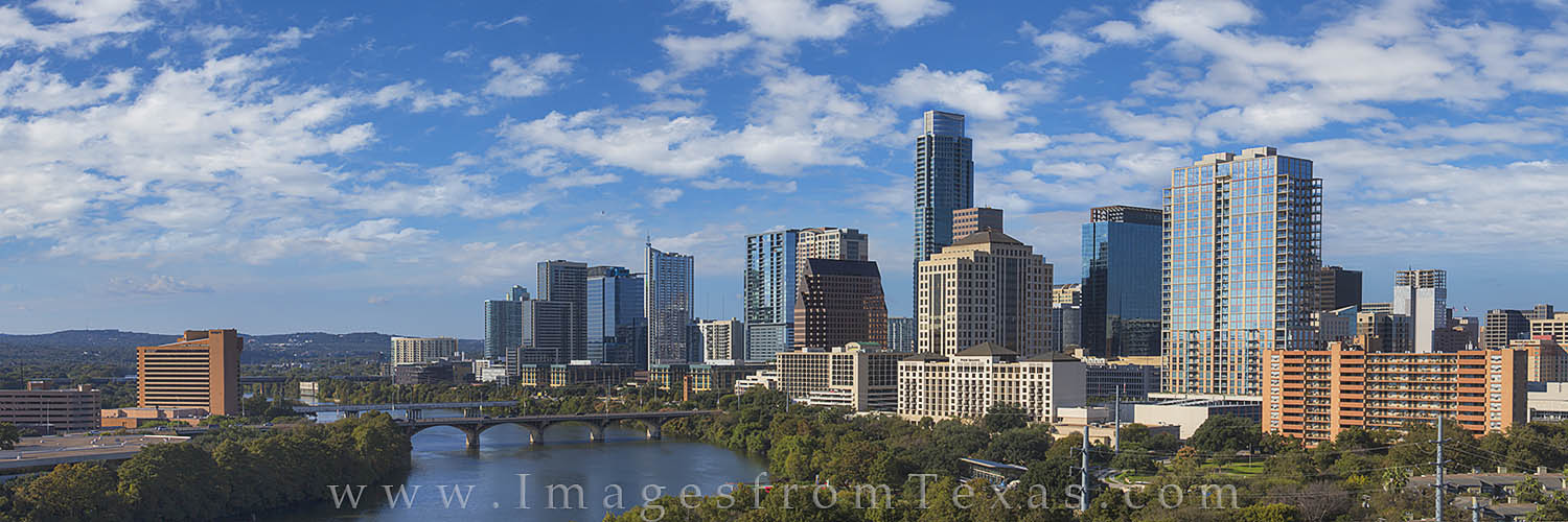 Lady Bird Lake shimmers beneath the blue sky as the Austin Skyline rises into the afternoon clouds. Congress and First Street...