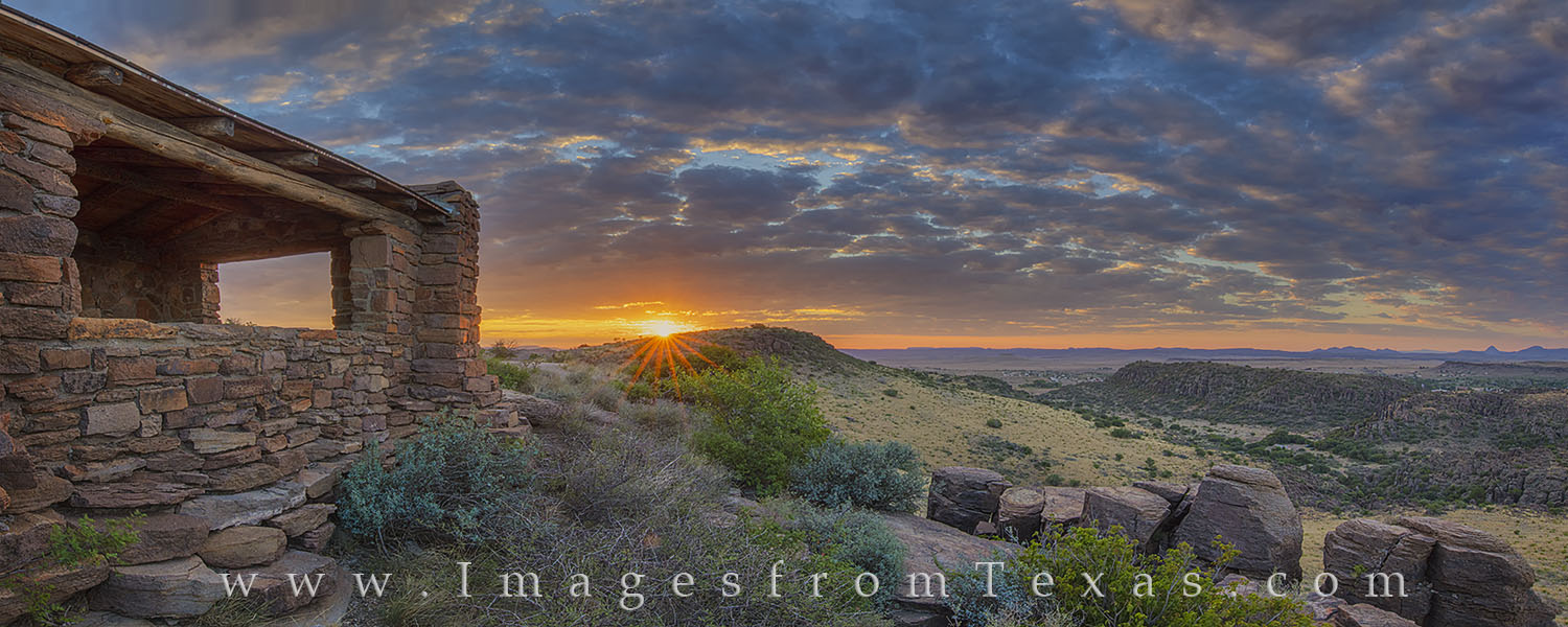 A sunburst appears over a distant ridge in this panorama from Davis Mountains State Park. This photograph consists of 21 images...
