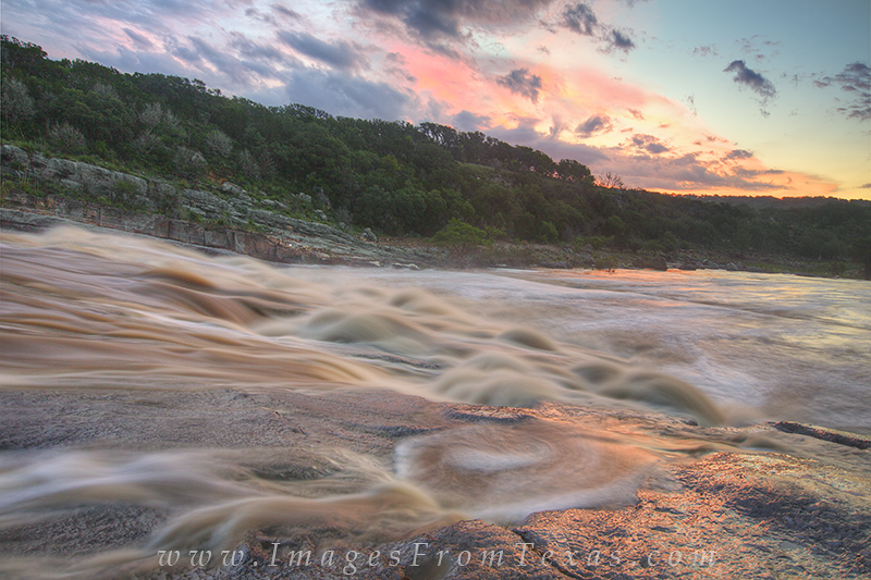 Sunrise over the muddy Pedernales River gives light to the raging river after a month of strong rains and storms. Many parts...
