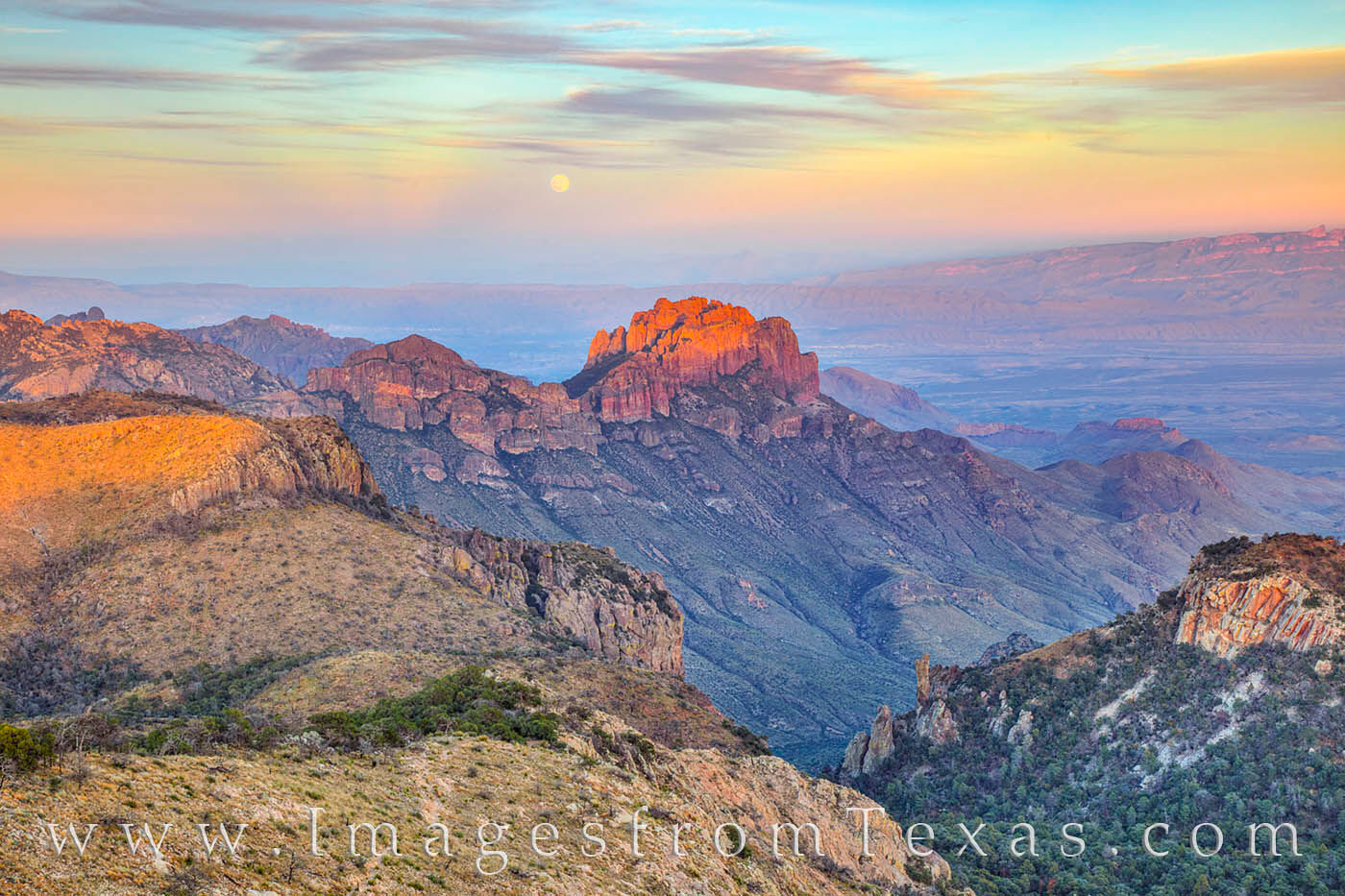 From Emory Peak, the full moon rising in the east is seen hanging over the distant mountains in Big Bend National Park. Taken...