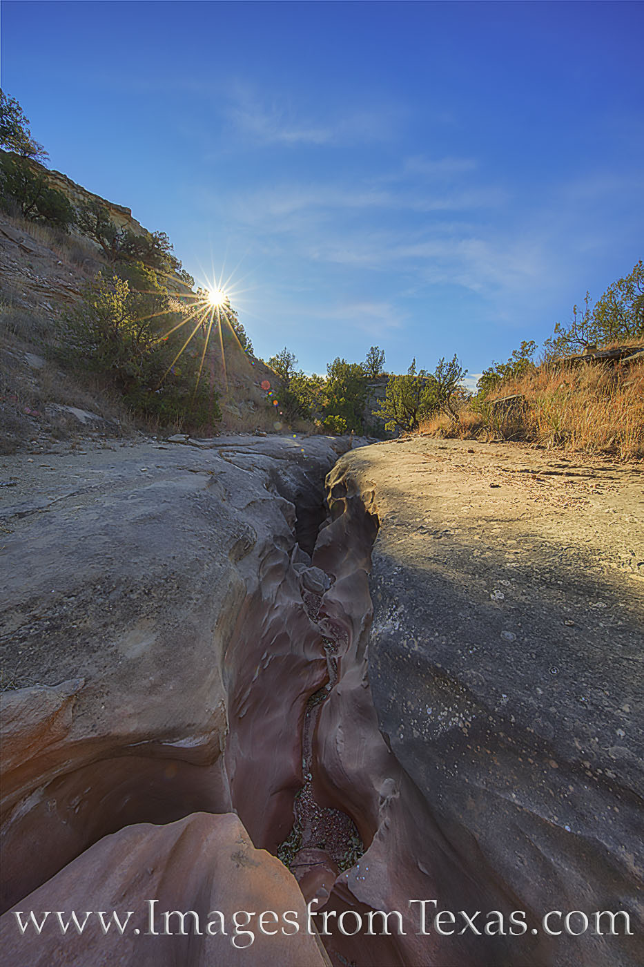 Sunlight begins to warm the November landscape in Palo Duro Canyon. This small crack in the ground is actually the entrance to...