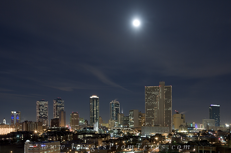 The full moon continues its progression into the night sky over downtown Fort Worth in this photograph from a cold December night...