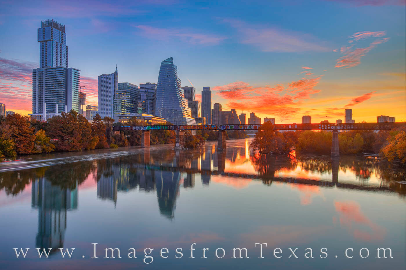 High rises in downtown Austin ascend from the banks of Ladybird Lake on a cold November morning. Along the shoreline, fall colors...