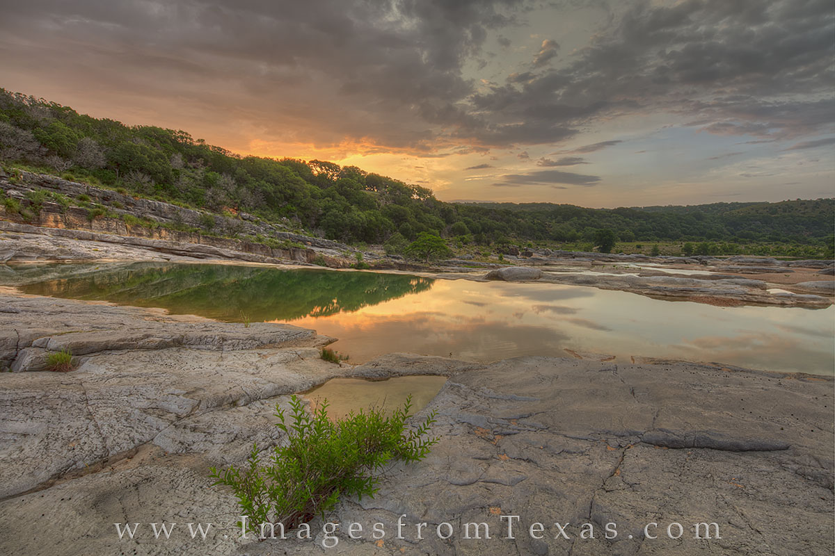 Orange and blue paint the sky as sunlight turns the Pedernales River valley into shades of warmth on a beautiful summer morning...