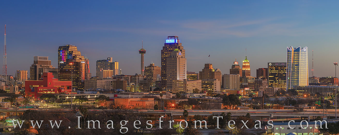 The San Antonio Skyline comes to life with light and color as daylight fades and evening spreads across the city. Here, the Frost...