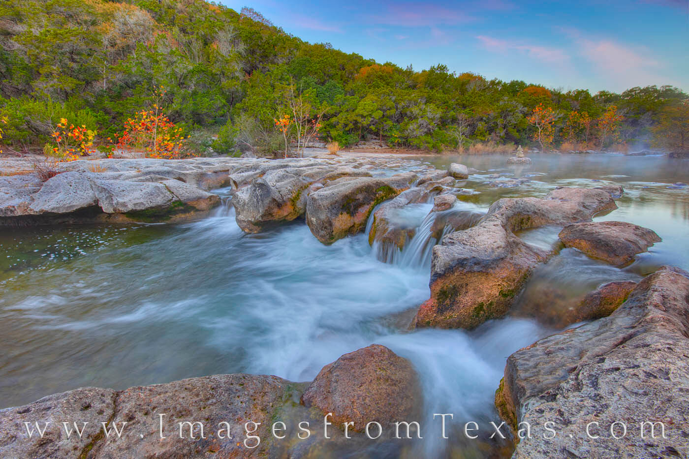 Sculpture Falls tumbles over limestone rocks on a very cold November morning. Splashes of color appear in the distance as a few...