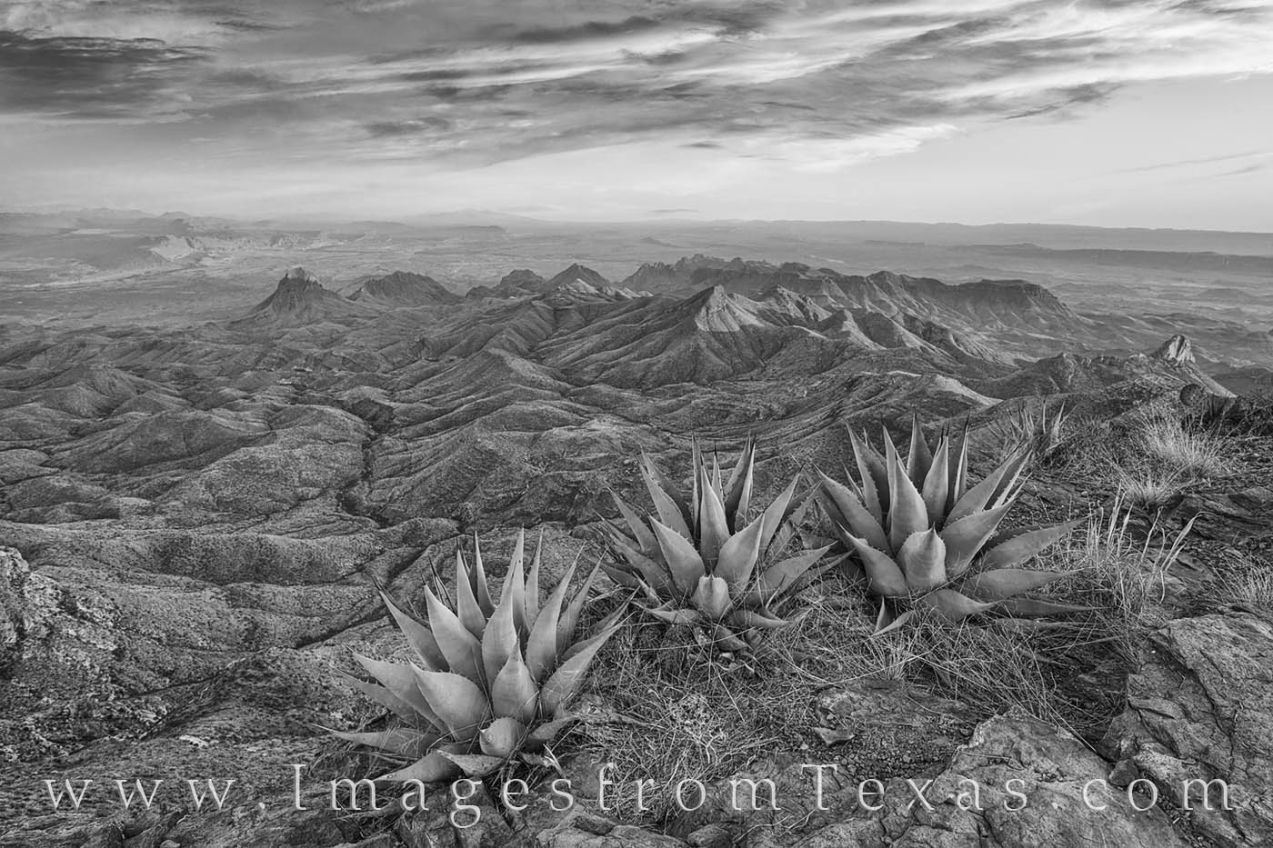 From the edge of the South Rim cliff, this landscape in black and white looks acoss the ancient Chisos Mountains, the Rio Grande...