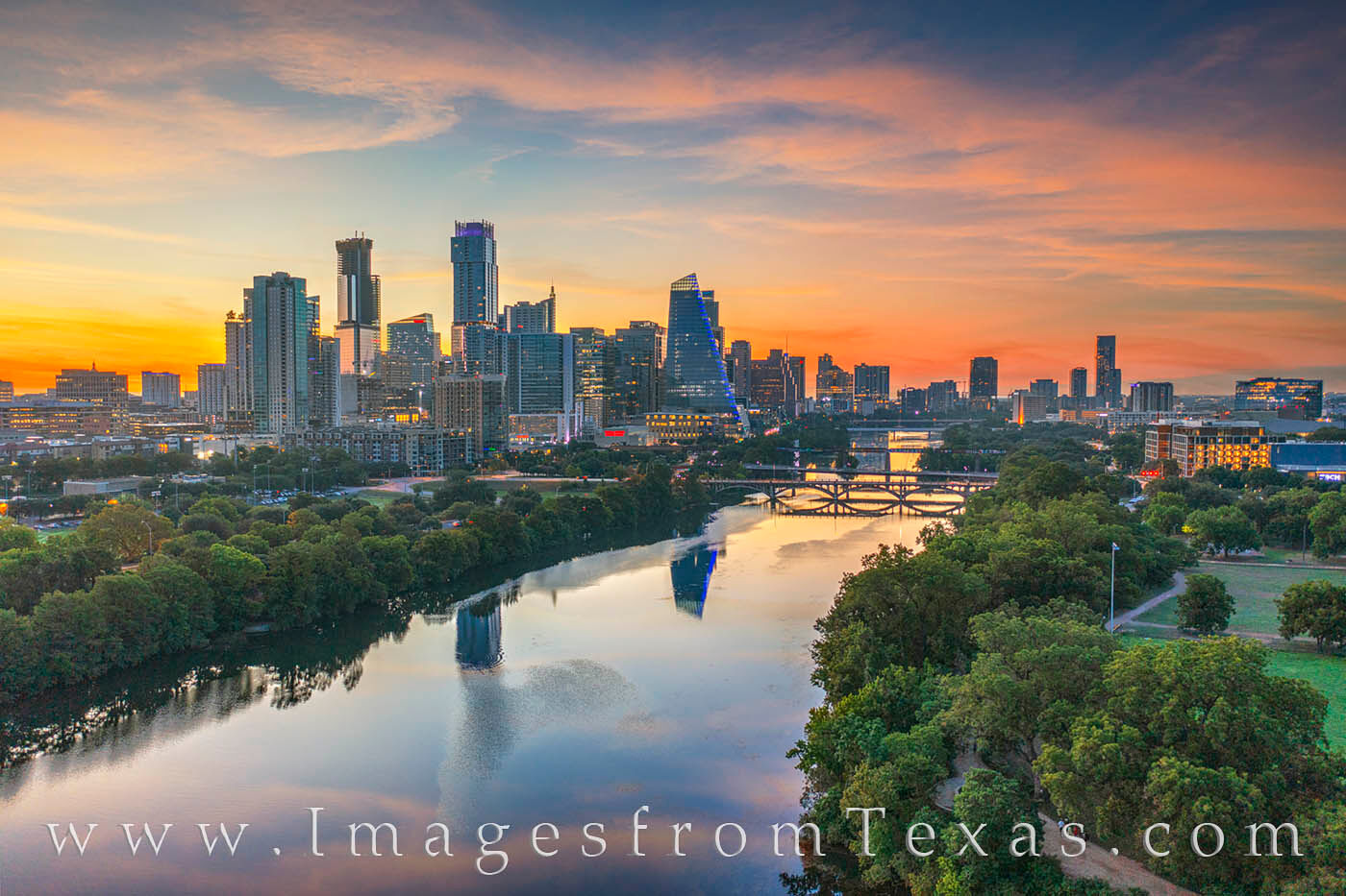 From high above the trees along the Zilker Park Hike & Bike Trail, the Austin skyline rises into a beautiful morning sky of pastels...