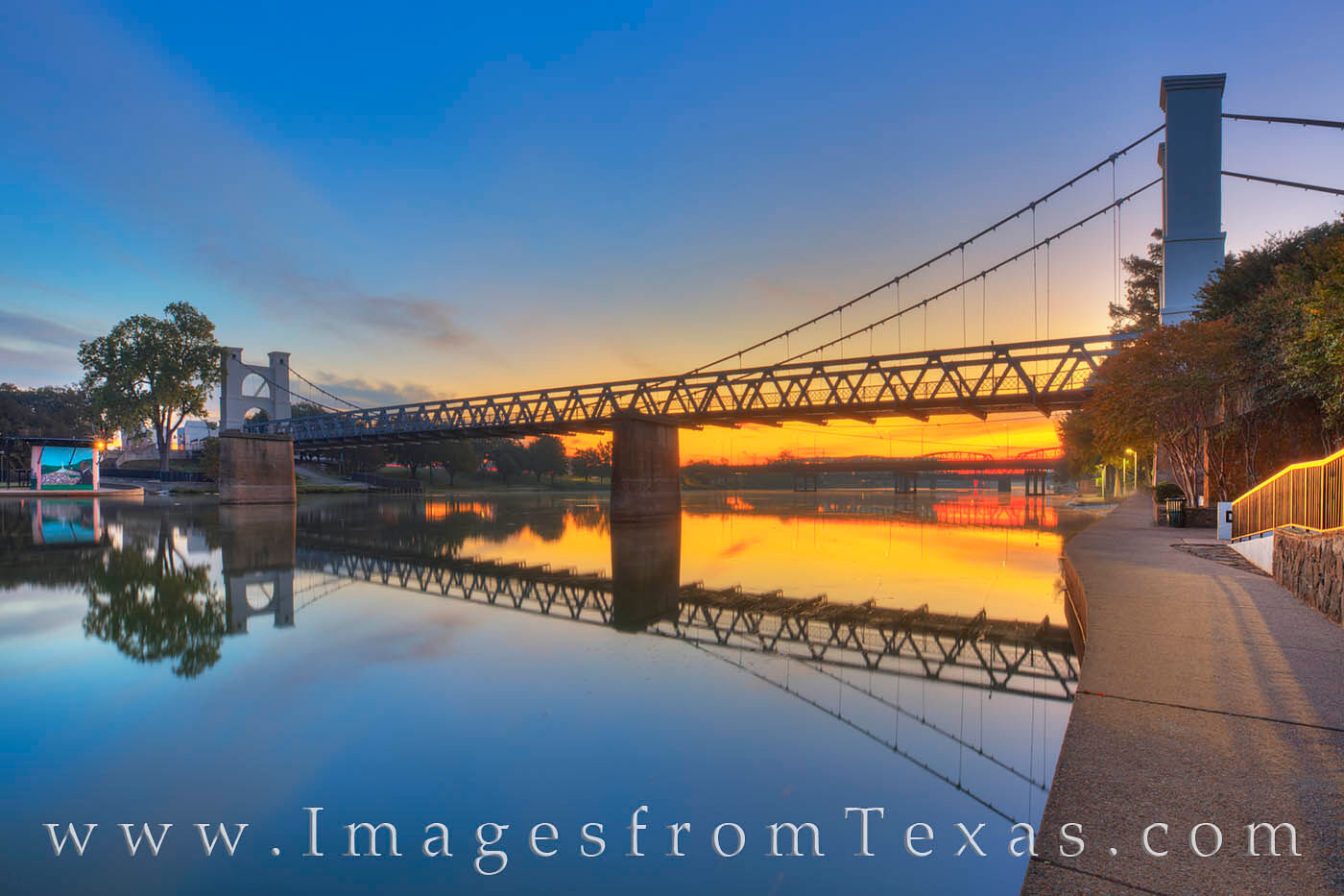 All is quiet along the Waco Riverwalk's east side. The still water of the Brazos River offers a perfect reflection of the Waco...
