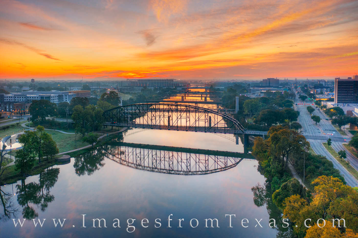 A beautiful sky brings a vibrant start to the day in Waco, Texas. Far below is the calm Brazos River spanned by several bridges...