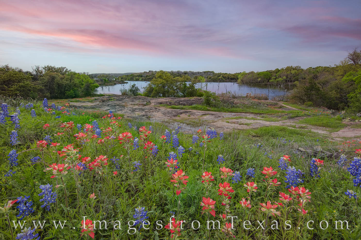 From a small overlook at Inks Lake State Park, bluebonnets and Indian paintbrush make for a nice foreground as the sunset adds...