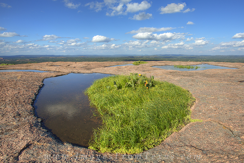 On a picture perfect late afternoon in the Texas Hill Country, the vernal pools at Enchanted Rock are full of water. Rains had...